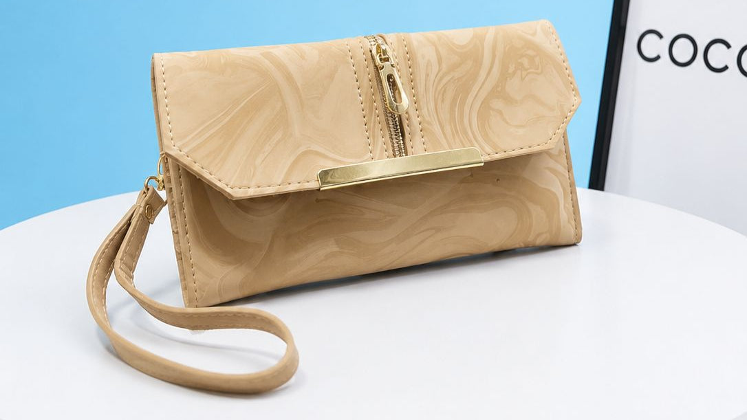 Beige handbag with gold accents on a white surface with a blue background