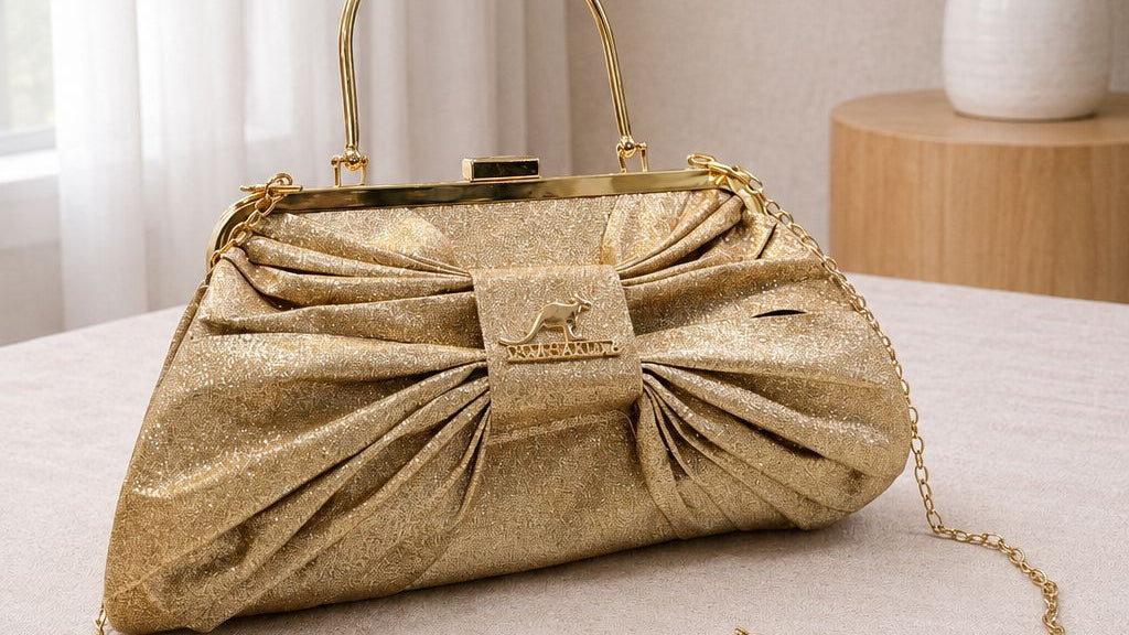 Gold handbag with a chain detail on a light surface with a neutral background