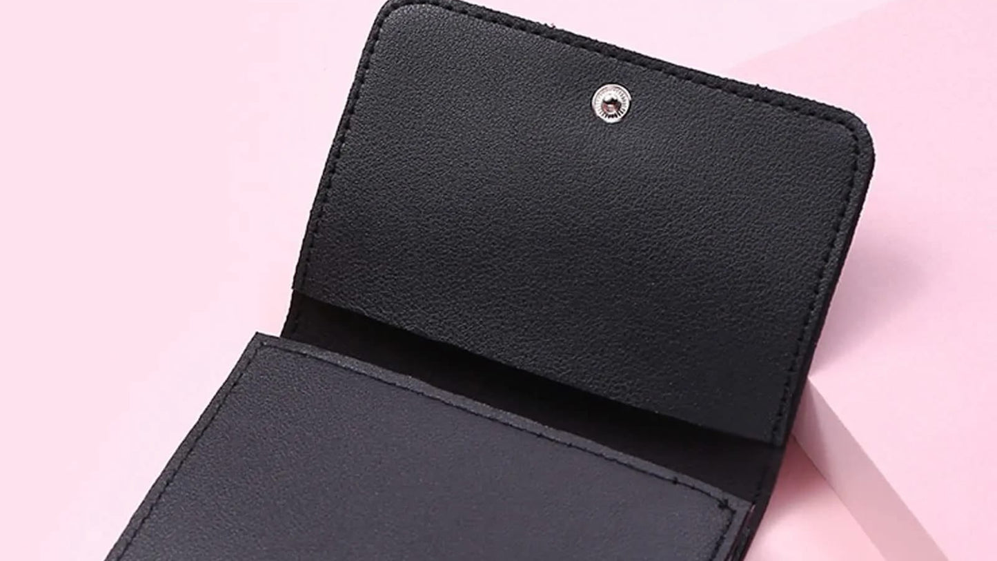 Black leather wallet on a pink background