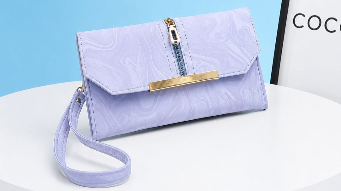 Purple handbag with gold accents on a white surface with a blue background