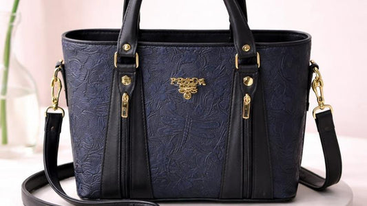 Blue handbag with gold accents on a white platform