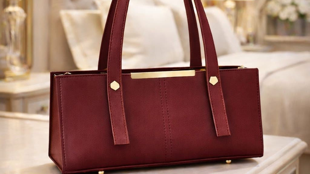 Maroon handbag on a table with a blurred background