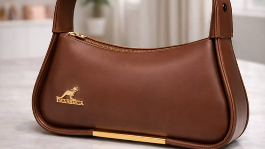 Brown leather handbag with a visible brand logo on a light surface.