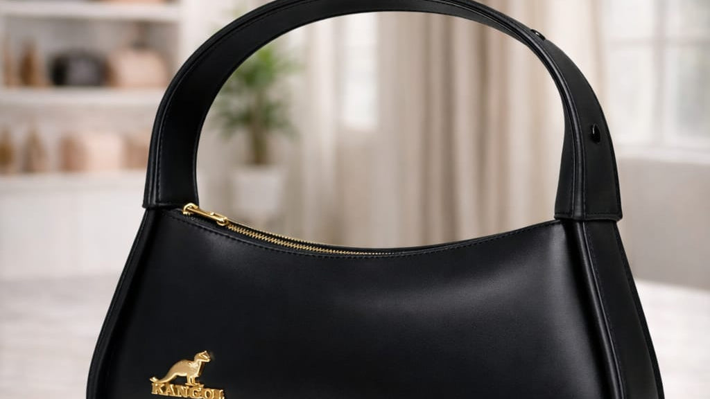 Black handbag with gold accents on a marble surface